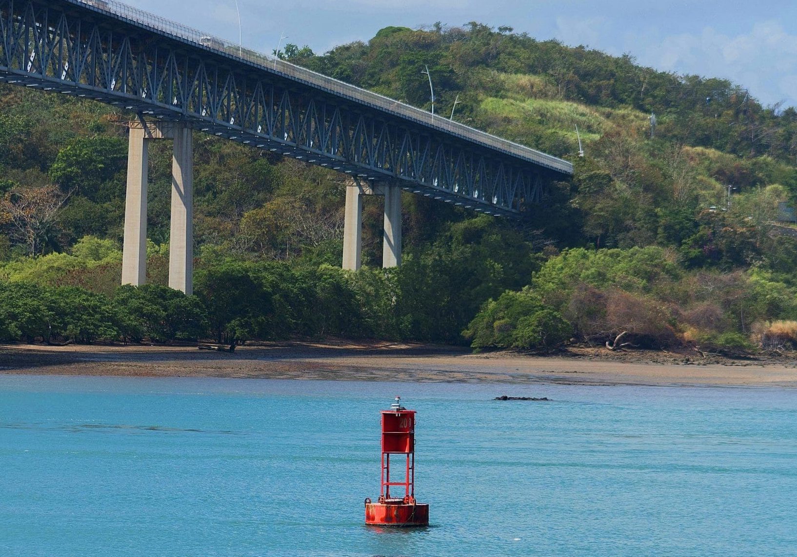 Scenic view of a buoy in Panama Canal with a bridge in the background.